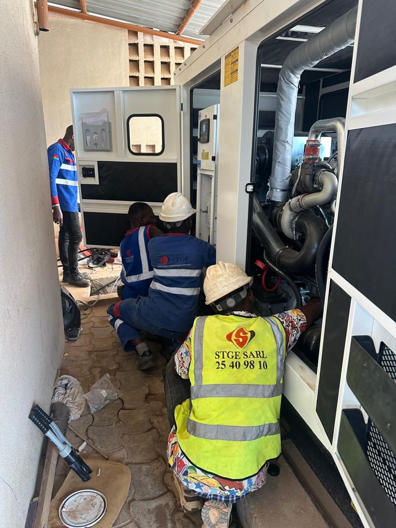 Technicien S.T.G.E raccordant un groupe électrogène